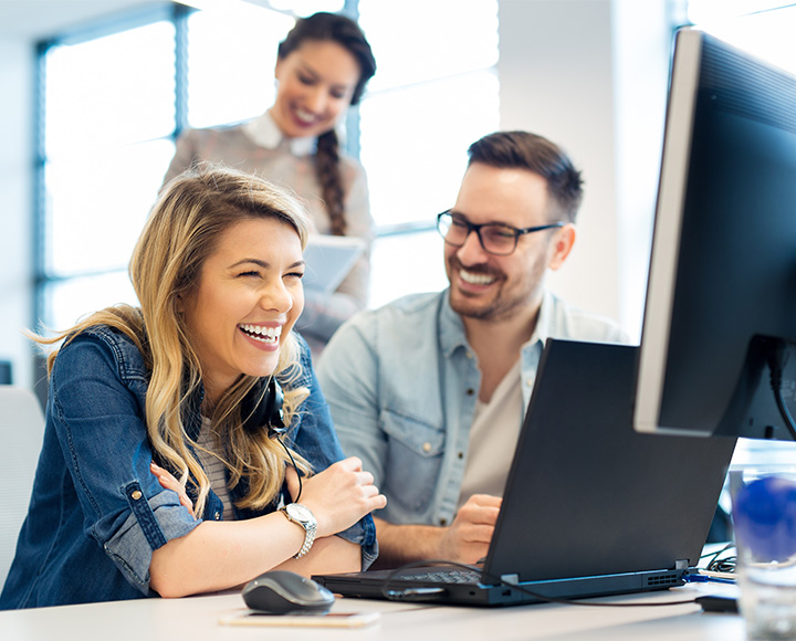 Happy team of employees working on a laptop Why Choose DMA